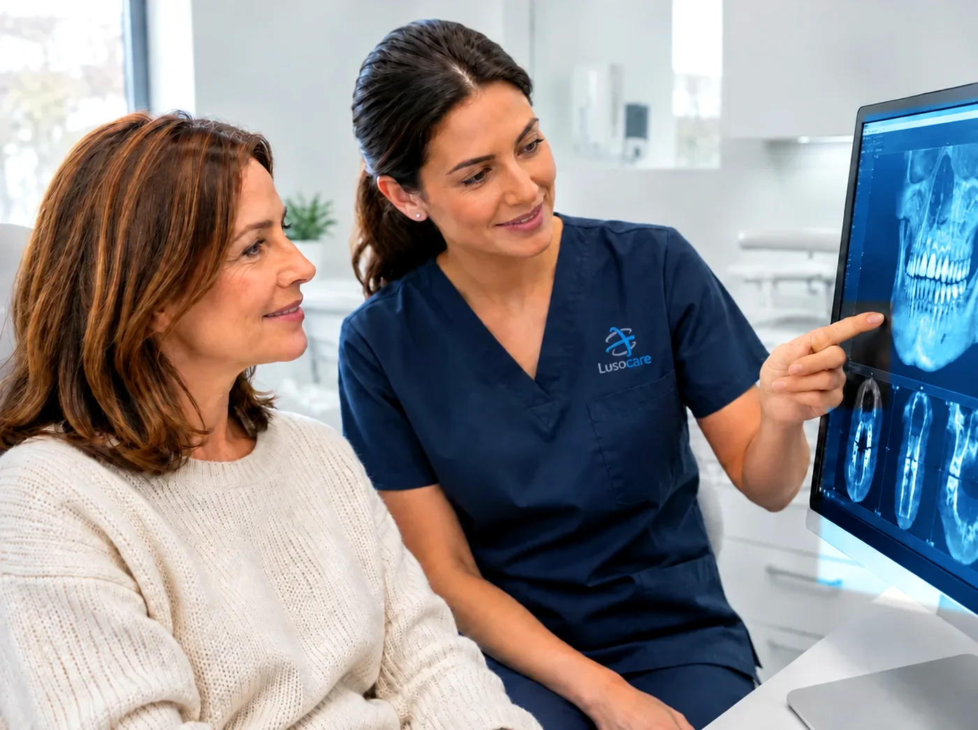 Médica dentista mostra a uma doente as imagens de CBCT 3D no monitor