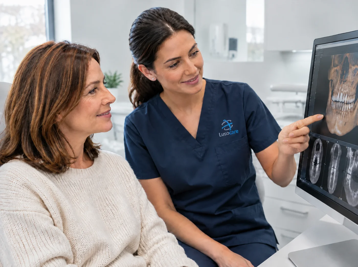 Médica dentista mostra a uma doente as imagens de CBCT 3D no monitor