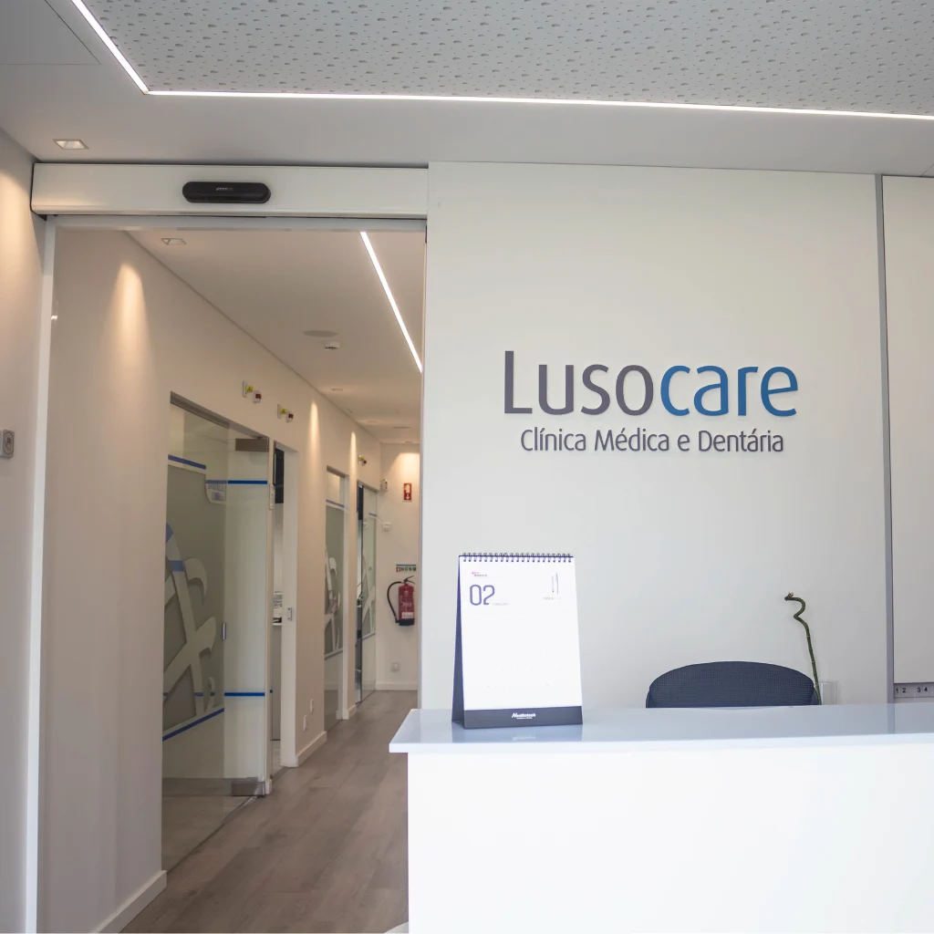 Recepção da clínica médica e dentária Lusocare com corredor ao fundo.