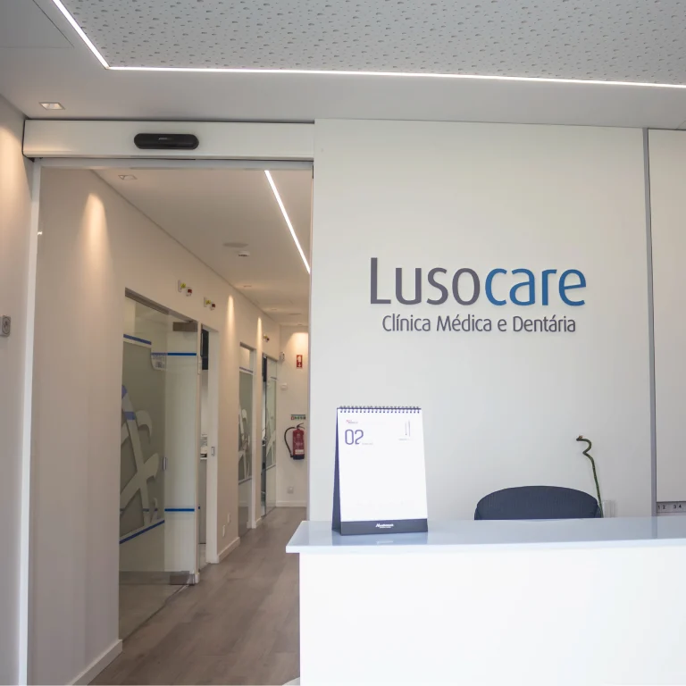 Recepção da clínica médica e dentária Lusocare com corredor ao fundo.