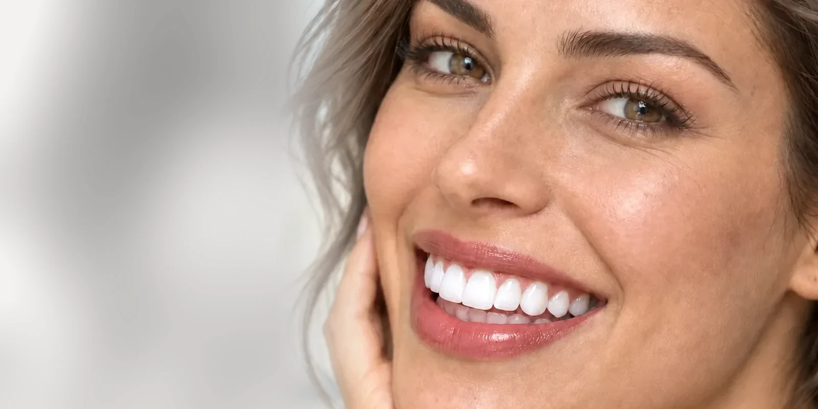 Mulher a sorrir com facetas de aspeto natural